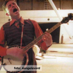 De platenkast van Robert van der Tol, interview over en met muziek. Foto toont Robert van der Tol spelend op de banjo, en zingend.